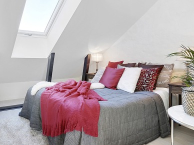 Biała sypialnia z szarą narzutą i różowymi poduszkami i pledem (21833)