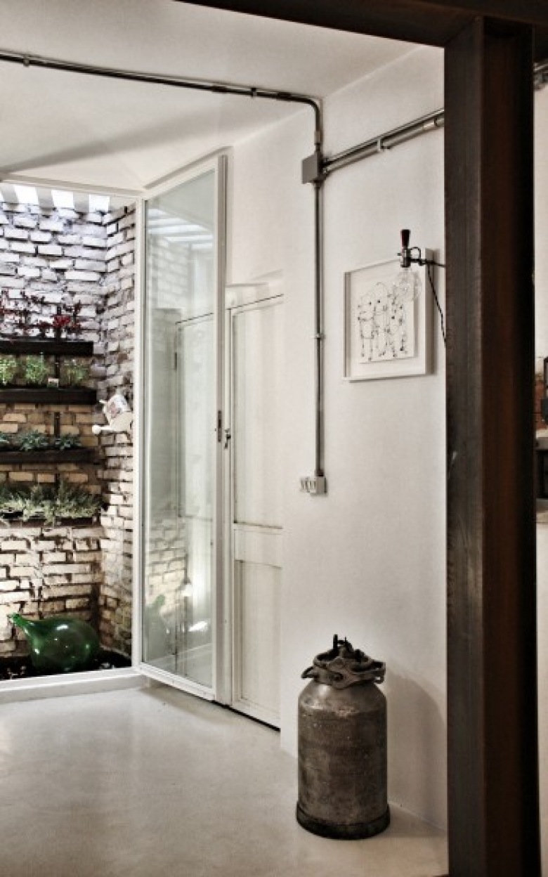 urokliwy, choć ciemny, mały apartament w Rzymie - światło doskonale pracuje w tym małym lofcie. doskonały ;pomysł na ukryty  za szkłem ogródek - super...