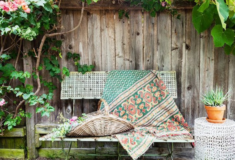 Stare drewniane deski i metalowa ławeczka towrzą sielską atmosferę w ogrodzie.