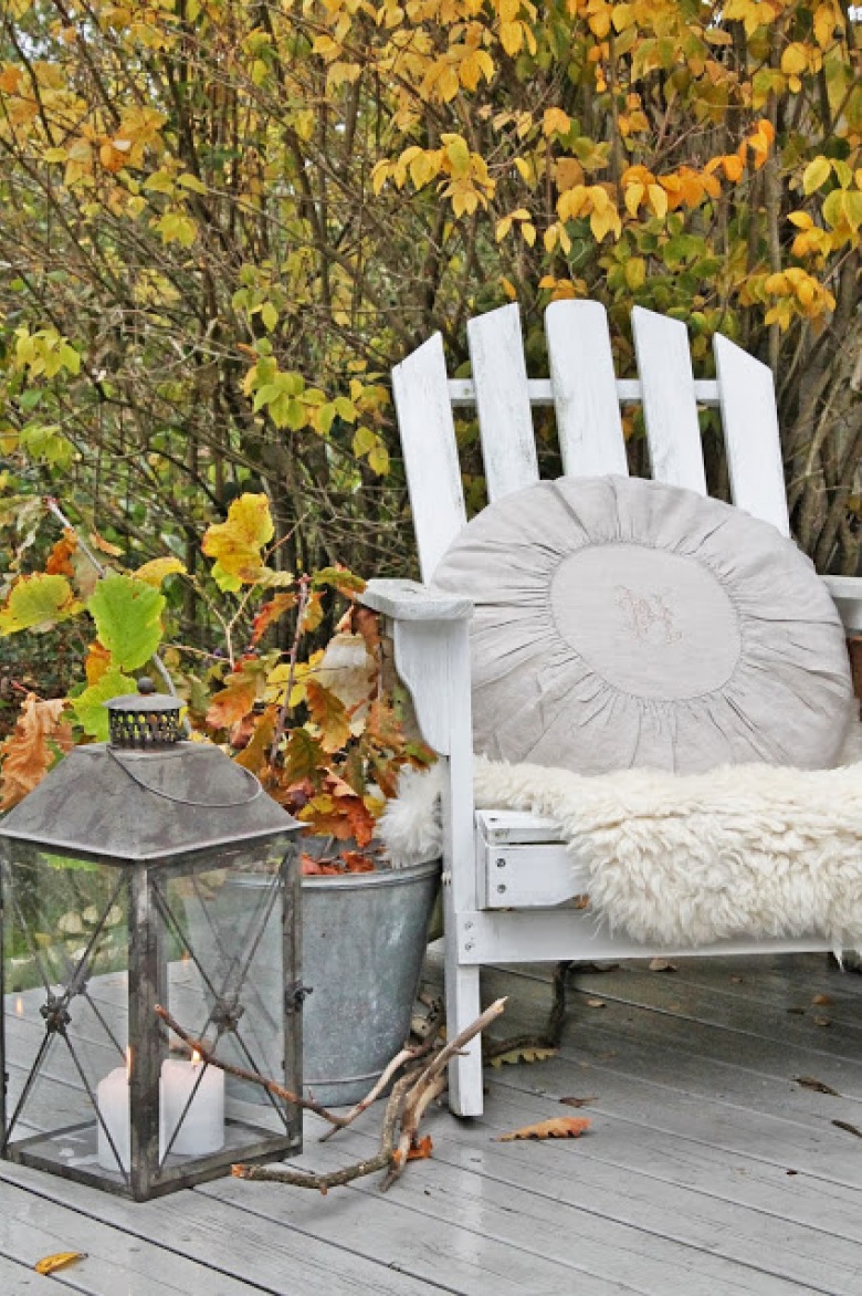 Aranżacja tarasu jesienią,jesienna aranzacja na balkon,jesienne inspiracje,szary lampion na tarasie,białe drewniane krzesło na balkon,biały fotel ogrodowy,okrągła poduszka na fotel,jesienne liście (35359)