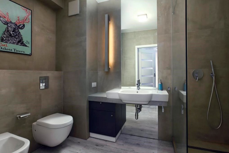 Ciemna łazienka łączy w sobie cechy skandynawskiego stylu z industrialnym klimatem. Jednolitą przestrzeń w kamiennym...