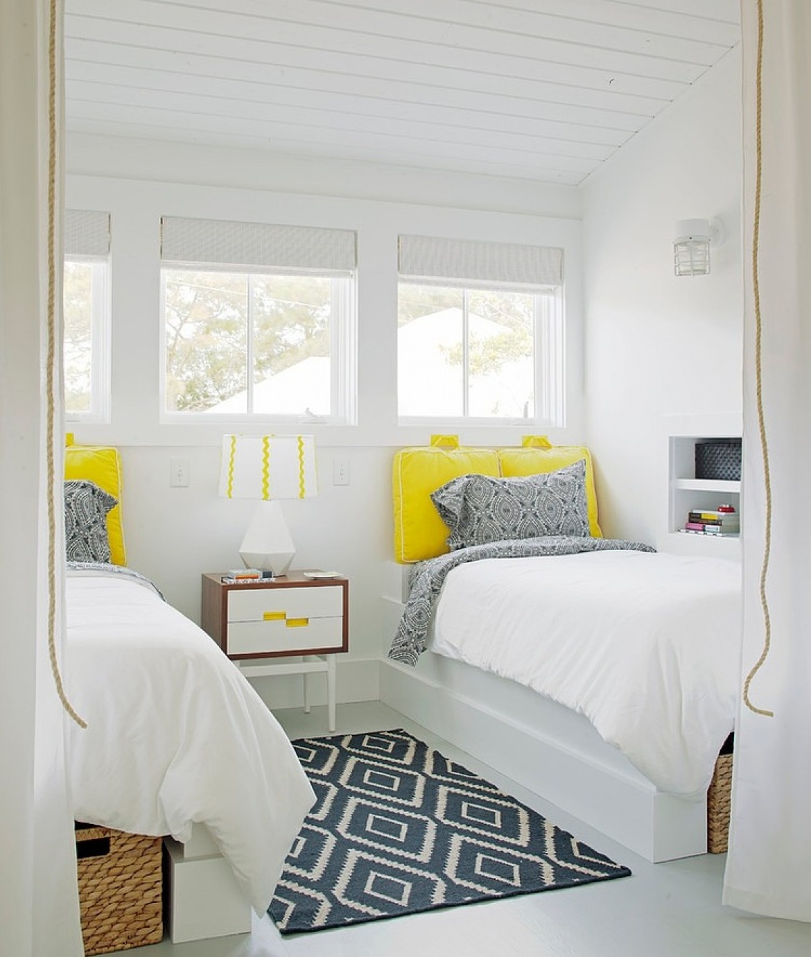 Biała sypialnia zszaro-białym dywanem w geometryczne wzory i żółtymi zagłówkami przy łóżku (23804)