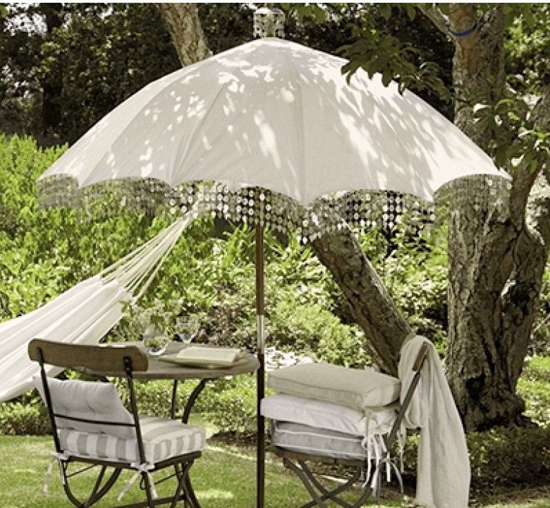 romantyczny obrazek ogrodu - lato w pełni,żar, cień parasola zabujany hamak - pełnia szczęścia....