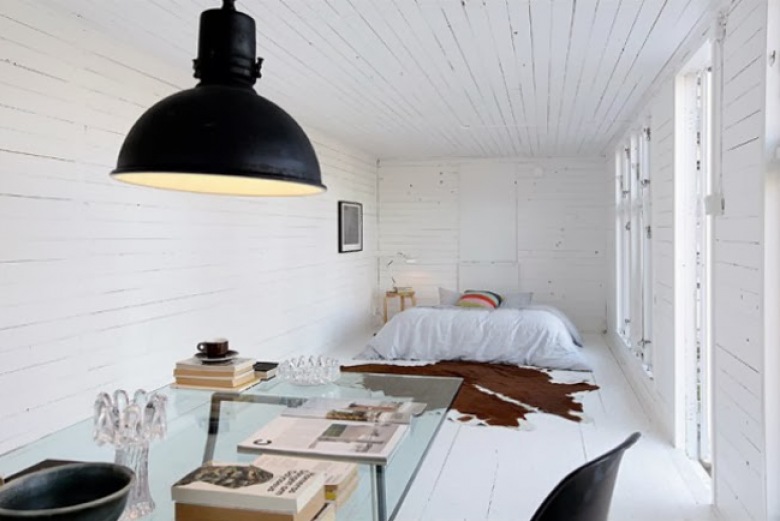 Biała sypialnia z czarną industrialną lampą,szklanym stołem i dywanem z byczej skóry (21632)