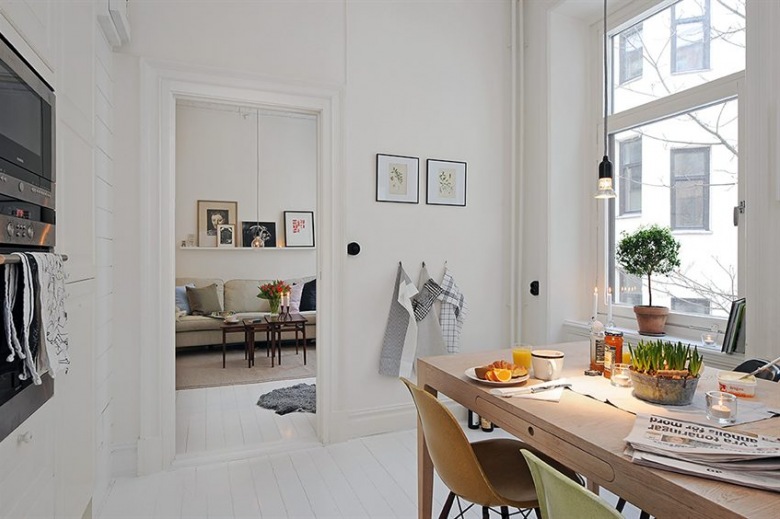 W białej kuchni urządzonej w skandynawskim stylu wygospodarowano miejsce na jadalnię. Drewniany stół podkreśla...