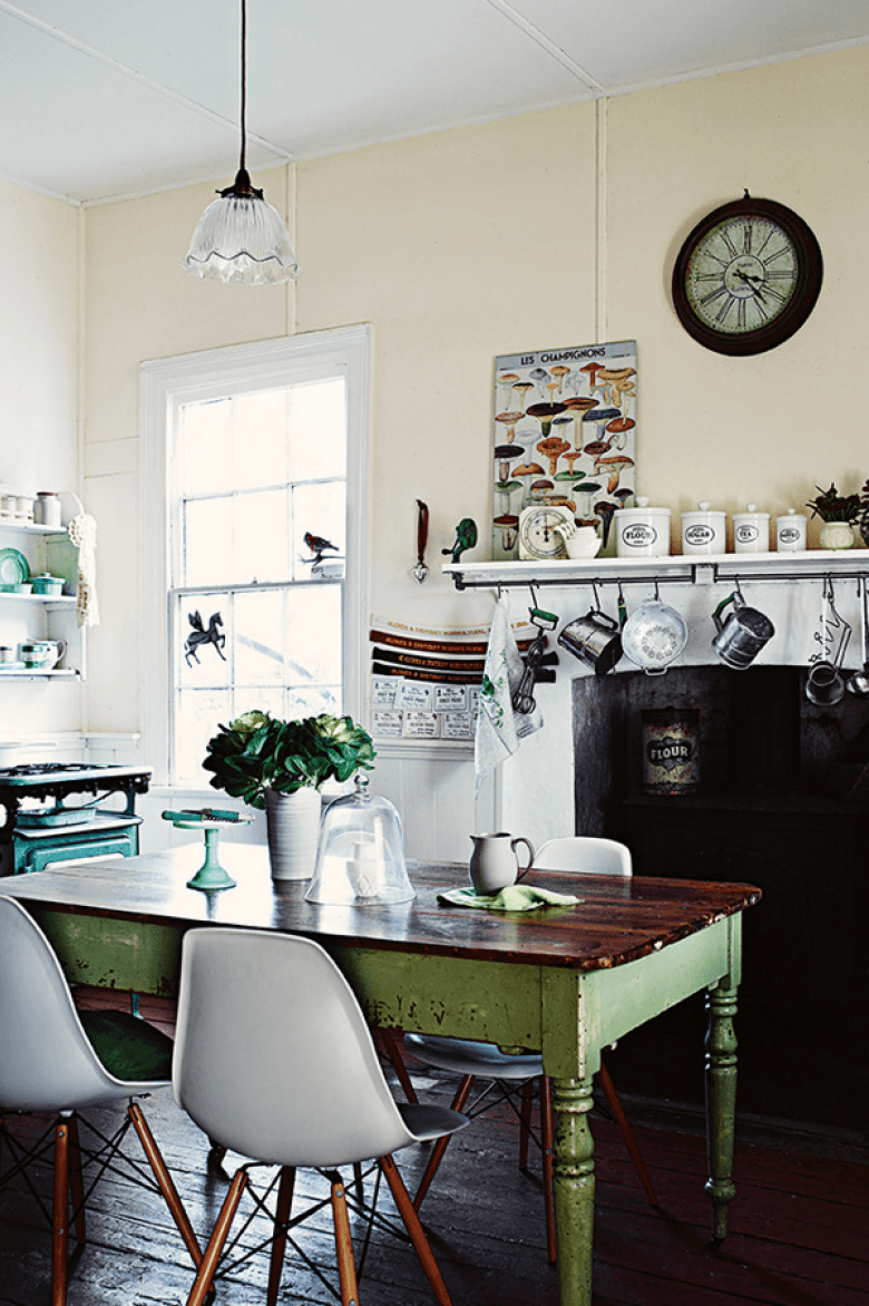 Zielony stół vintage z drewna,nowoczesne krzesła VITRA i wiejski kominek z wiszącymi kuchennymi akcesoriami (24160)