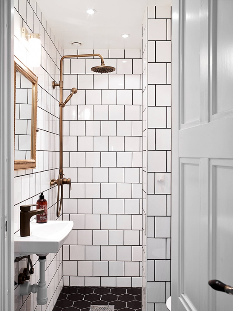 Białe kwadratowe kafeki na ścianie, czarne sześciokątne na posadzce w łazience z miedzianym prysznicem retro (24882)