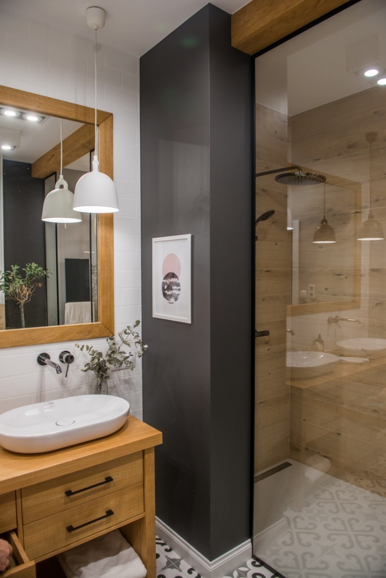 Aranżacja łazienki jest stylowa i nowoczesna. Elegancki klimat zapewnia między innymi czarna ścianka, która oddziela...