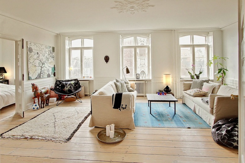 Nowoczesne obrazy,naturalne drewno,tkane dywany i proste witryny w skandynawskim salonie (25404)