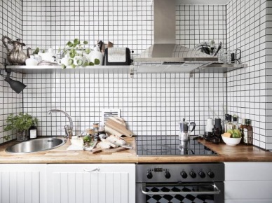 Biala kuchnia skandynawska z drewnianym blatem,stalowym okapem z półkami i białą kosteczką płytką na ścianie (25981)