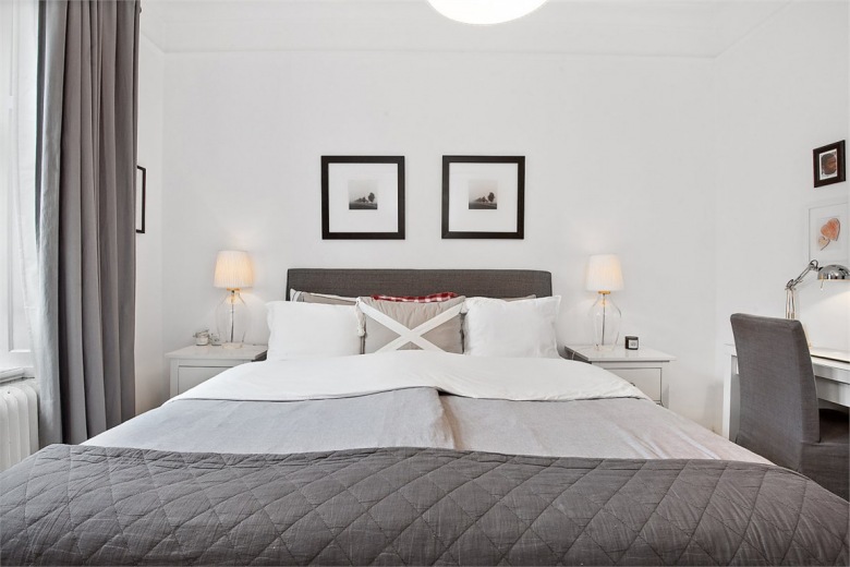 Symetryczna aranżacja sypialni kojarzy się z ładem i harmonią. Czarne dodatki w wyraźny sposób dekorują wnętrze, podkreślają jego poważny charakter. Szarą pościel i narzutę dopasowano do ramy łóżka o podobnym...