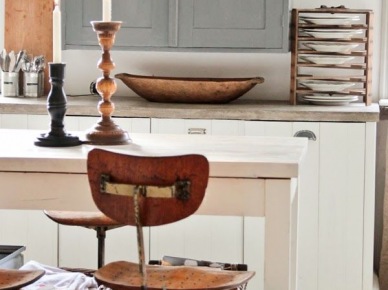 Szare szafki wiszące w białej kuchni i rustykalne detale z drewna i metalu, czyli miski, deski deserowe i pojemnik,i z wikliny (25641)