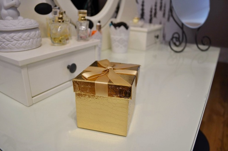 Flakoniki perfum i rozmaite dodatki pełnią dekoracyjną funkcję na białej toaletce. Złote pudełeczko wnosi do aranżacji...
