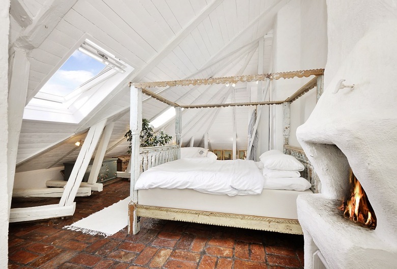 Czerwona terakota,bielone belki i łóżko w drewnianej ramie w białej sypialni na poddaszu (21516)