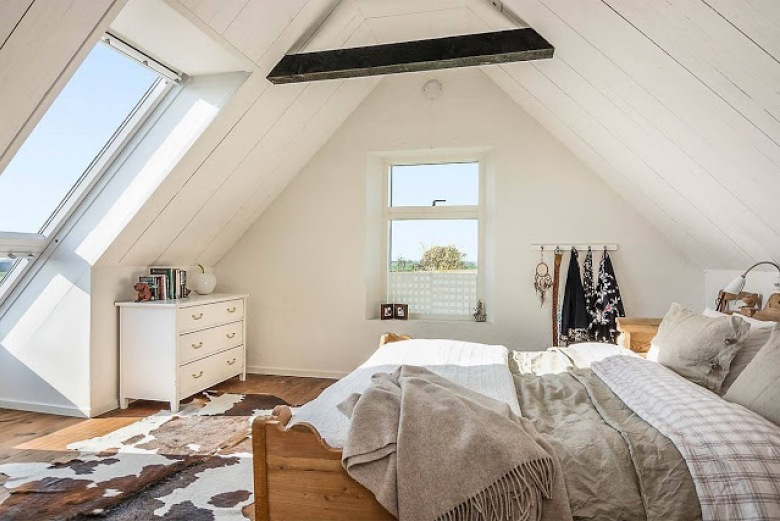 Biała sypialnia pod skośnym dachem,dywana ze skóry bydlęcej,biała komoda i drewniane łóżko (28624)
