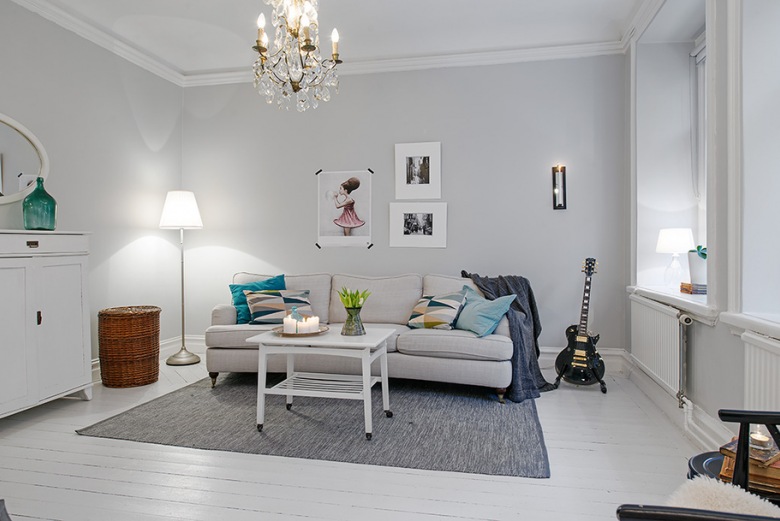 Aranżacja skandynawskiego salonu z białą podłogą,turkusowymi dekoracjami i szarym dywanem (21616)