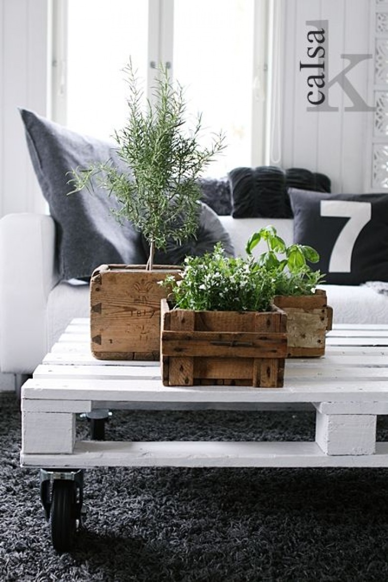 Biały stolik z palety na kólkach i drewniane skrzynki z roślinami w biało-szarym salonie (25308)