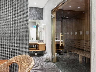 Mała sauna z prysznicem w aranżacji biało-czarnej łazienki z wiklinowym fotelem i drewnianymi meblami (24713)