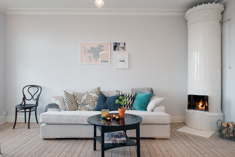 Kolorowe i wzorzyste poduszki na białej sofie w salonie skandynawskim (22819)