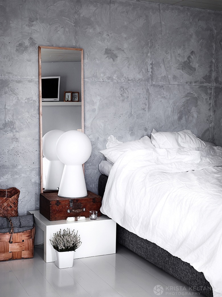 Sypialnię urządzono w lekko industrialnym stylu, do którego przyczynia się szara ściana o strukturze betonu....