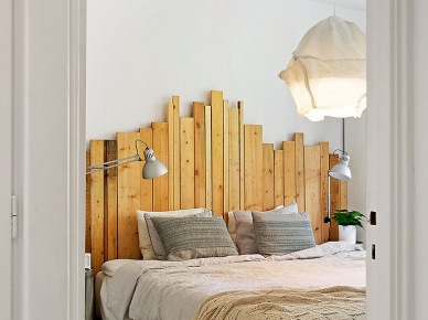 Drewniane wezgłowie z surowych desek i lampa z drutu i bawelny nad łóżkiem w sypialni (23791)