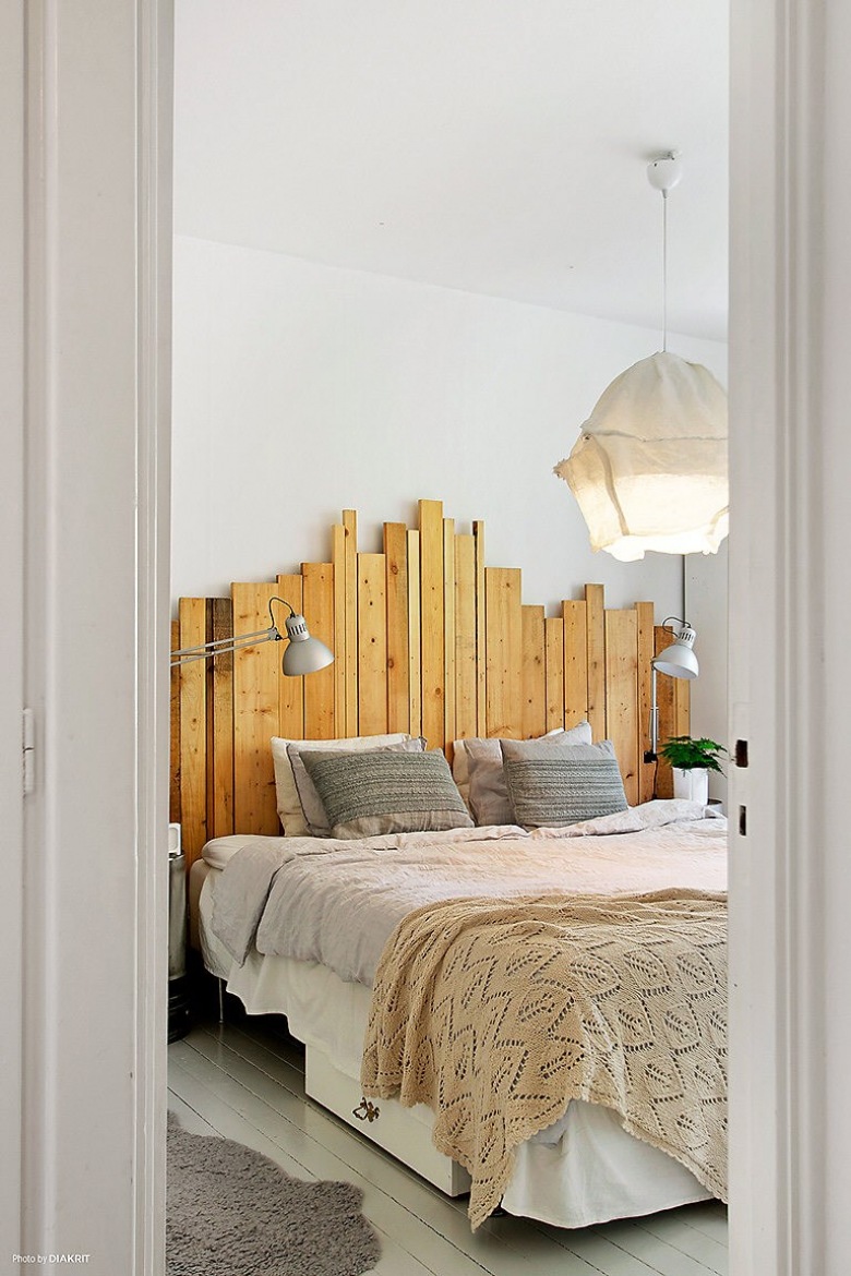Drewniane wezgłowie z surowych desek i lampa z drutu i bawelny nad łóżkiem w sypialni (23791)