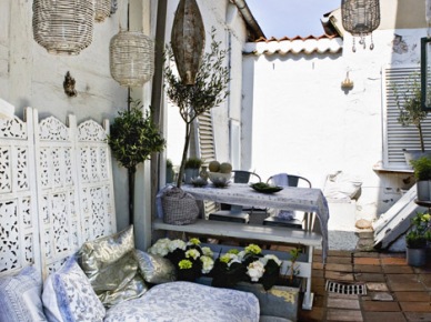 Wiszące lampiony na drewnianej pergoli,biało niebieskie poduszki i ażurowe dekory w marokańskim stylu na tarasie (24028)