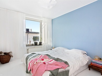 Biała sypialnia skandynawska z jedną niebieską ścianą przy łóżku (23405)