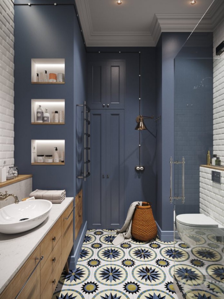 Aranżacja łazienki bazuje na dużym kontraście kolorystycznym. Podświetlane półki na kosmetyki czy kubełkowa umywalka zdradzają inspirację stylem...