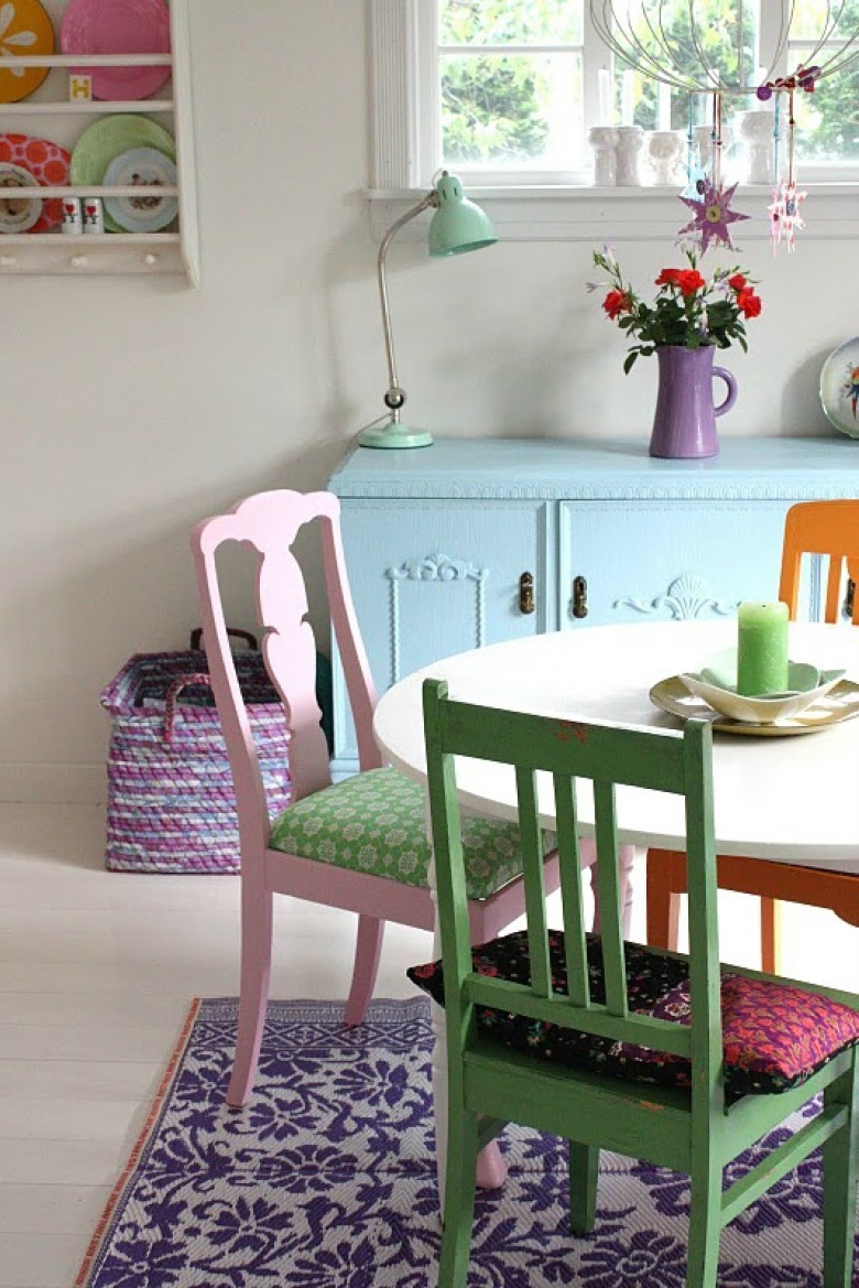 Okrągły bały stół z pomarańczowym, zielonym i różowym krzesłem (21994)