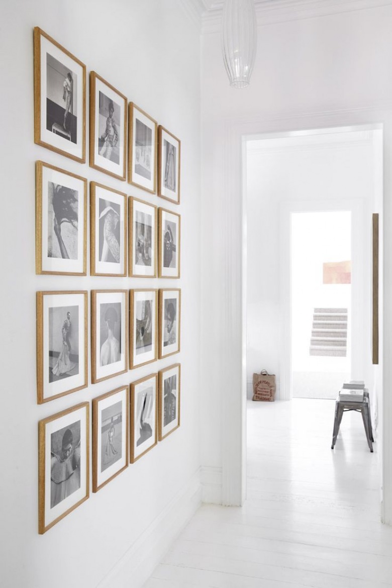 Galeria czarno-białej fotografi w drewnianych ramkach na białej ścianie w przedpokoju (25768)