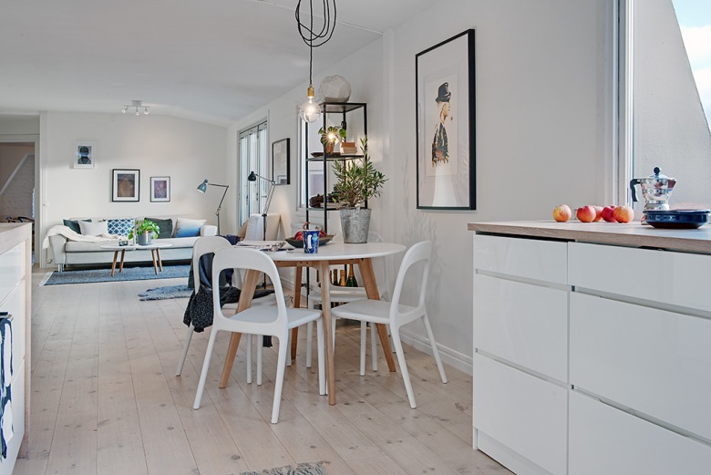 Okrągły stół z białymi nowoczesnymi krzesłami na otwaretej przestrzeni kuchni z salonem (21127)