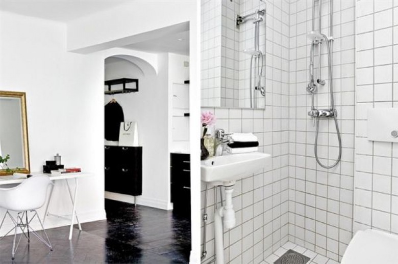 bardzo eleganckie i proste male mieszkanie, które zostało urządzone w białym i czarnym kolorze. białe ściany, czarna...