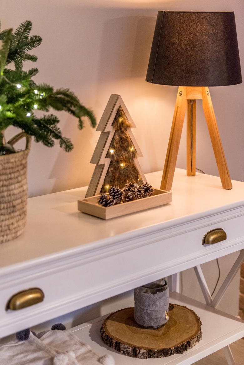 Drewniane dekoracje są bardzo naturalne i wnoszą wiele ciepła do salonu. Mała ozdoba w kształcie choinki ładnie komponuje się z podstawą lampy...