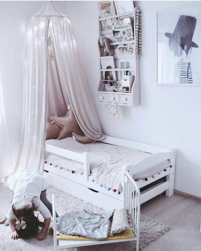 Baldachim zawieszony nad łóżeczkiem w pokoju dziecięcym tworzy wspaniałą oazę dla malucha. Półka na ścianie pomaga...