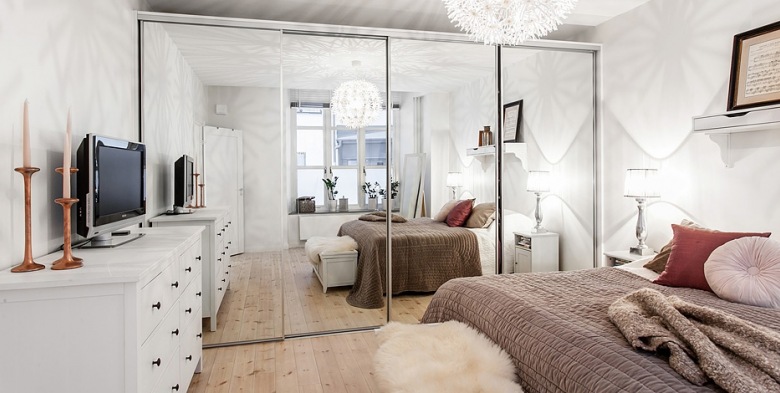 Biała sypialnia z lustrzaną szafą, białą komodą i beżowo-różową dekoracją łóżka (21849)