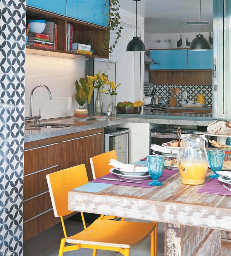 Przecierany stół w kolorowej kuchni, gdzie żółte i błękitne dodatki dodają energicznej atmosfery.
