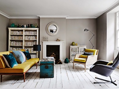 Szare ściany w salonie z kominkiem,żółtą sofą,turkusowym kufrem i białą podłogą z patynowanych desek (25060)