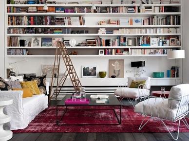 Nowoczesna aranżacja salonu z bialymi półkami na ścianie,drabiną,nowoczesnymi metalowymi fotelami w bieli i różowym dywanem vintage (26181)