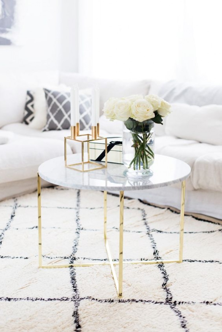 Spokojną aranżację salonu urozmaica lekko wzorzysty dywan. Stoliczek kawowy ze złotymi nogami i marmurowym blatem prezentuje się niezwykle...