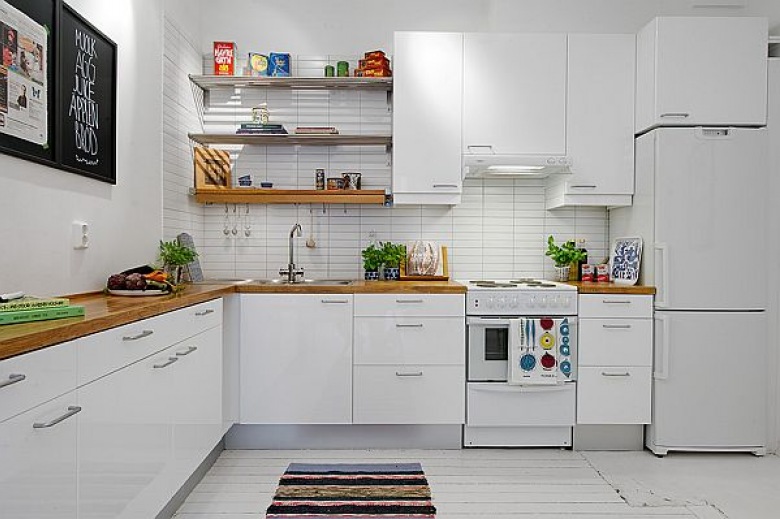 Biała kuchnia z drewnianym blatem i metalowymi półkami (20927)