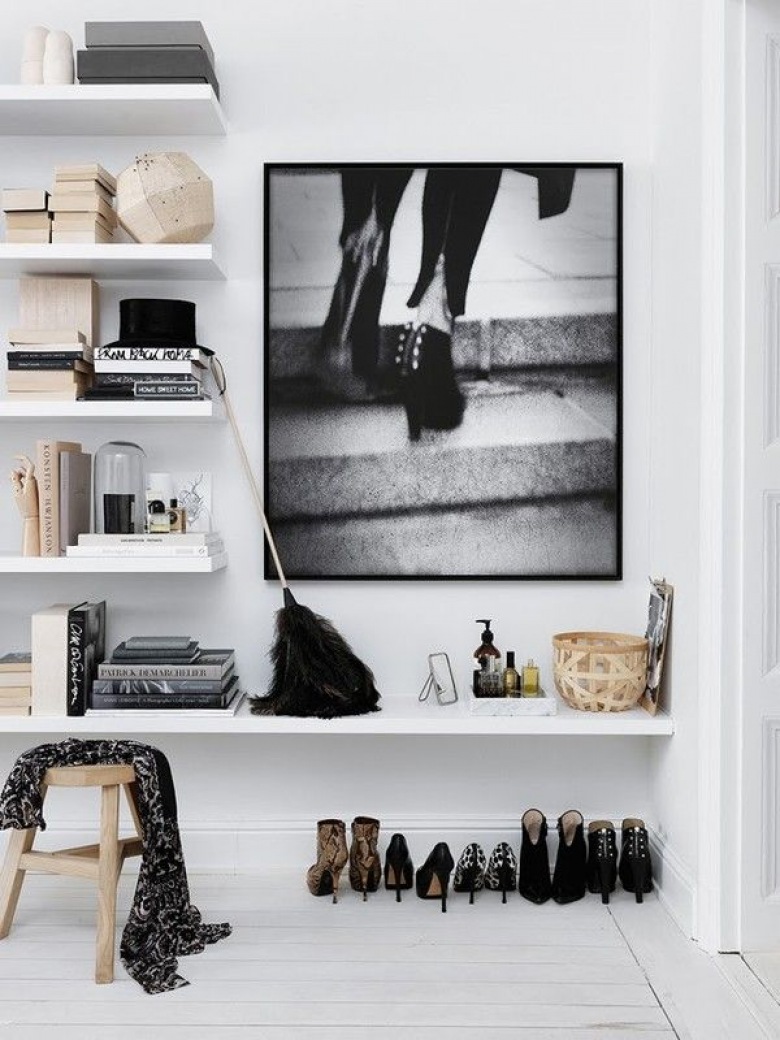 Białe malowane deski na podłodze,białe półki na scianie,drewniany stołek i biało-czarna fotografia na ścianie w przedpokoju (26062)