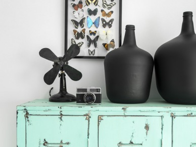 Turkusowa komoda z metalu,czarne pękate wazony i dekoracja na ścianę z kolekcją motyli (22275)