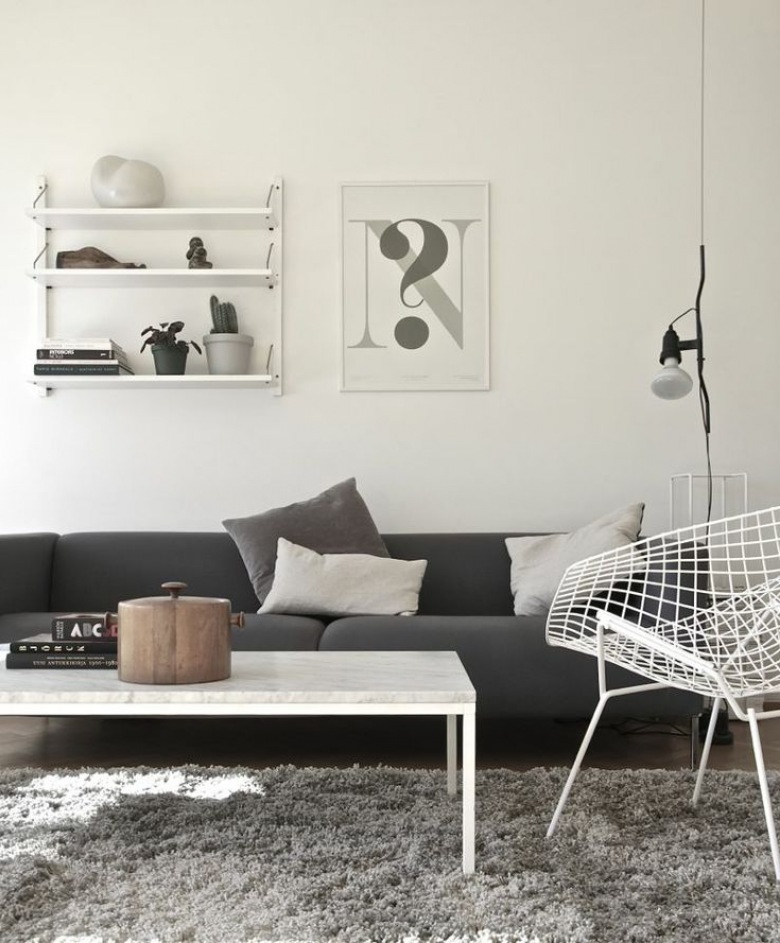 Szara nowoczesna sofa,biały stolik,biały metalowy fotel z azurami i grafiki z pólkami na ścianach (24883)