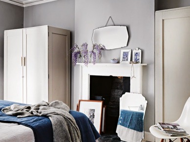Szare ściany,dekoracyjne skandynawskie lustra,granatowa narzuta, i biała szafa w sypialni (25065)