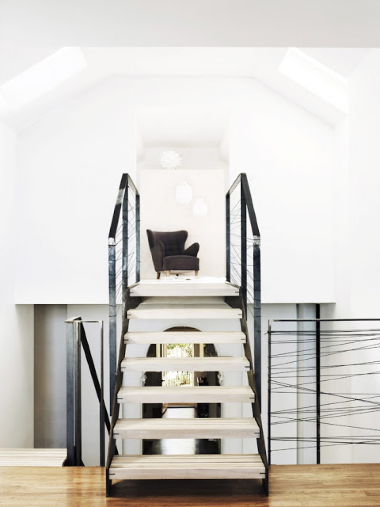 Minimalistyczne , proste, otwarte schody , a białe ściany kontrastują z jakimś zaciemnionymkolorem ziemi i drewna ......