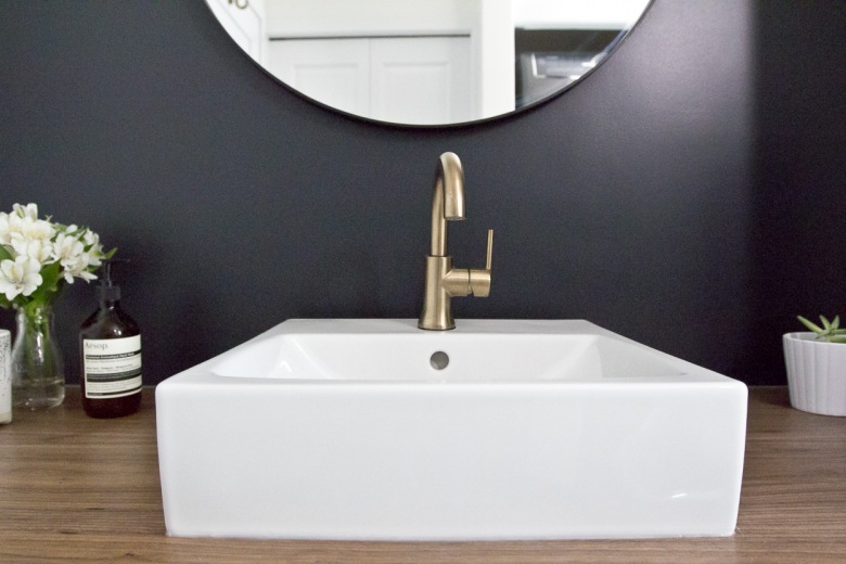 Wyjątkowy szyk nadaje łazience złoty kran. Tworzy spory kontrast z czarną ścianą i pomimo tego, że ma prosty i...