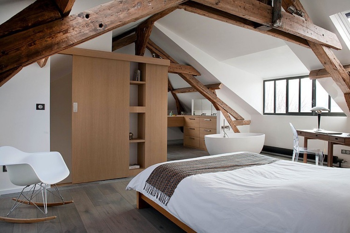 Owalna wanna w biało-brązowej sypialni z drewnianymi belkami i nowoczesnymi krzesłami (24980)