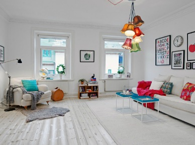 Aranżacja skandynawskiegobiałego salonu z kolorowymi poduszkami i lampą (22027)