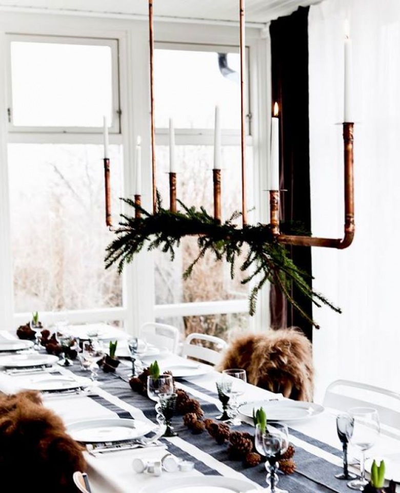 Wiszący świecznik z miedzianych rurek z gałązka igliwia nad świątecznym stołem w stylu skandynawskim (27415)